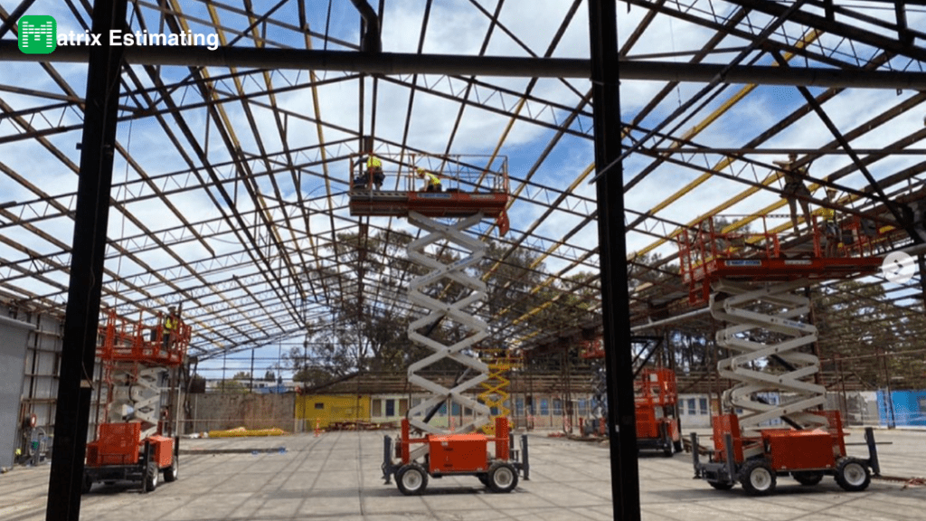 Construction workers installing metal roof structure at an industrial site.